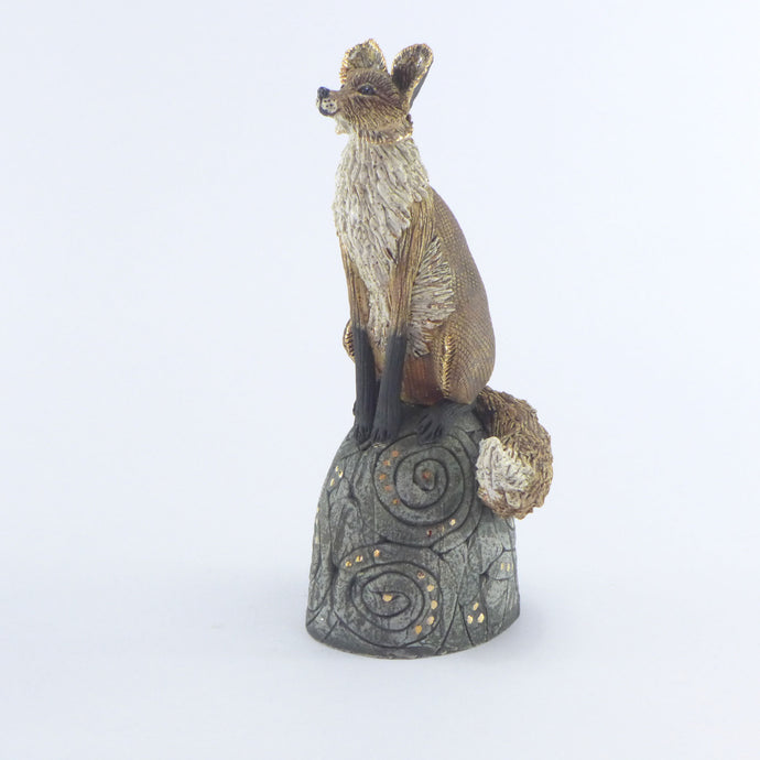 Small sitting fox on a hill brown